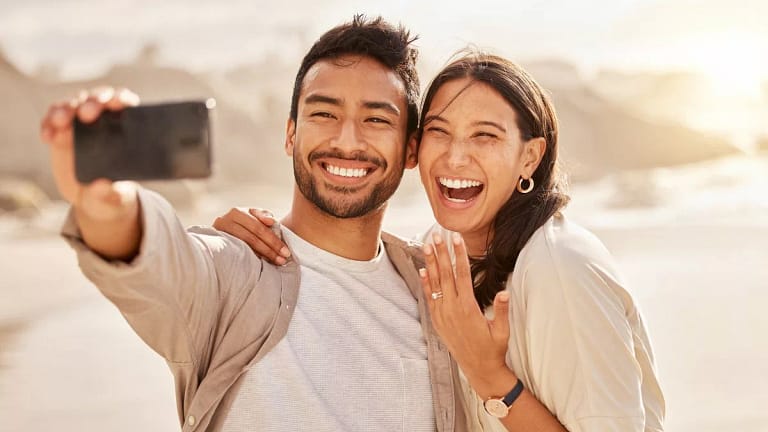 Couple smiling and taking selfie with engagem.width .jpg