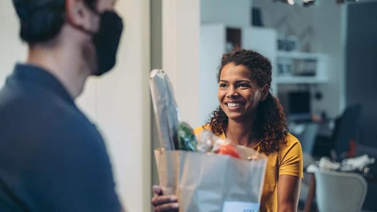 Woman accepting a delivery of groceries. EZB.width .jpg