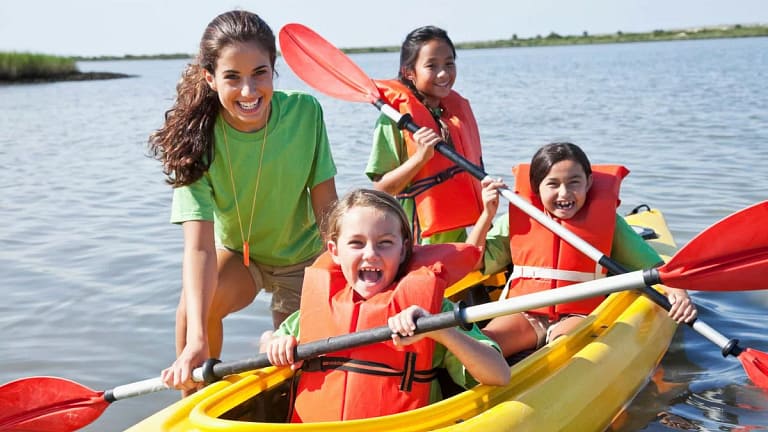 Young adult girl helping kids in a kayak FaRw.width .jpg