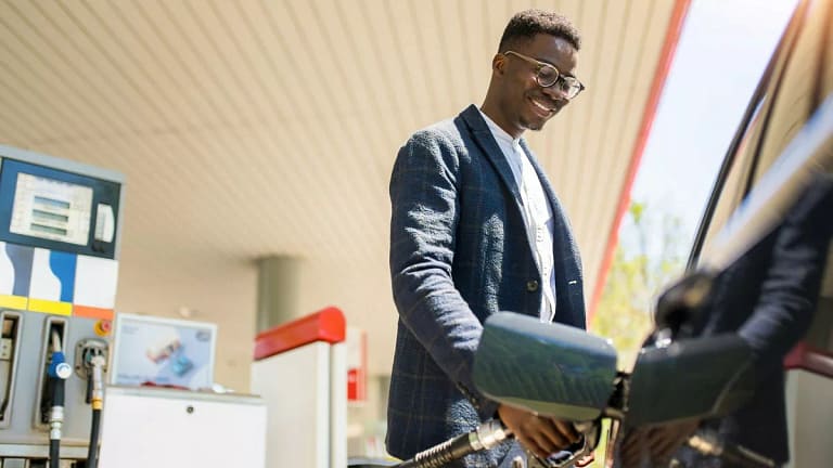 person filing up their car with gas AhVsk.width .jpg