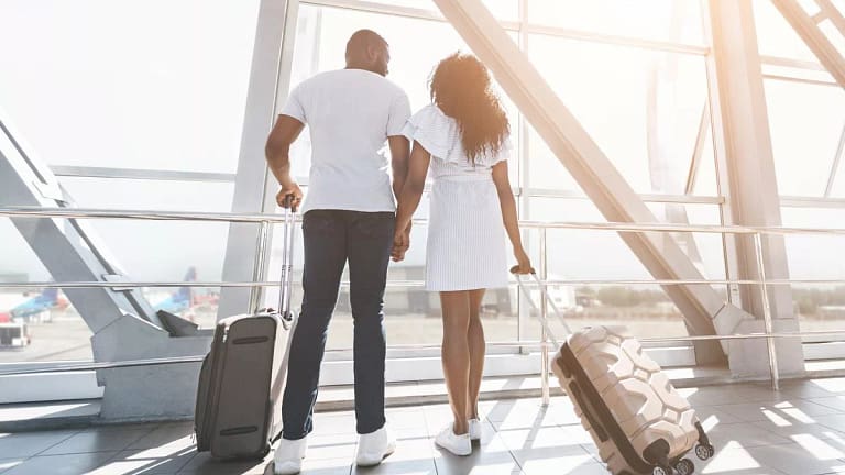 two people with suitcases holding hands hNDS.width .jpg