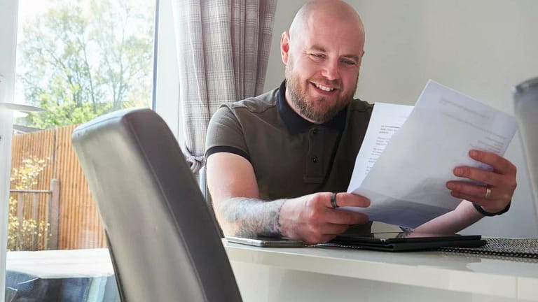 Man smiling reading a letter rvqbJE.width .jpg