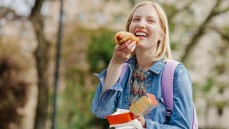 Young woman eating a hotdog snzotnb.width .jpg