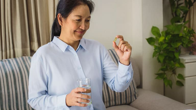 asian woman holding a pill.jpg