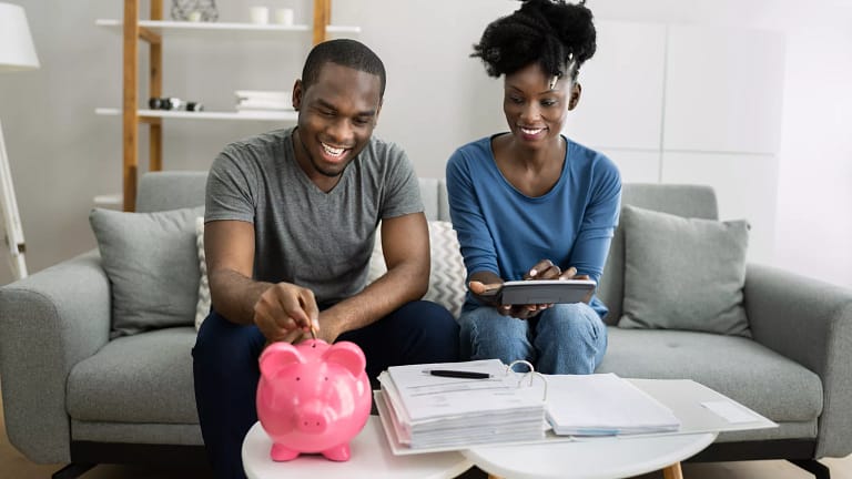 couple saving money in pink piggy bank.jpg
