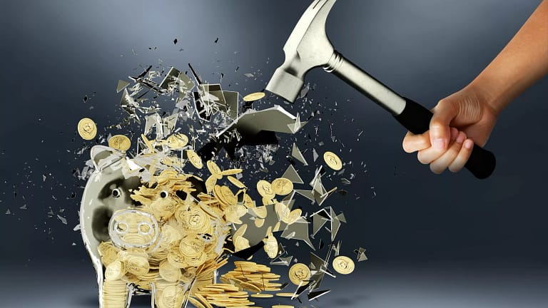 getty images person smashing piggy bank with hammer.jpeg