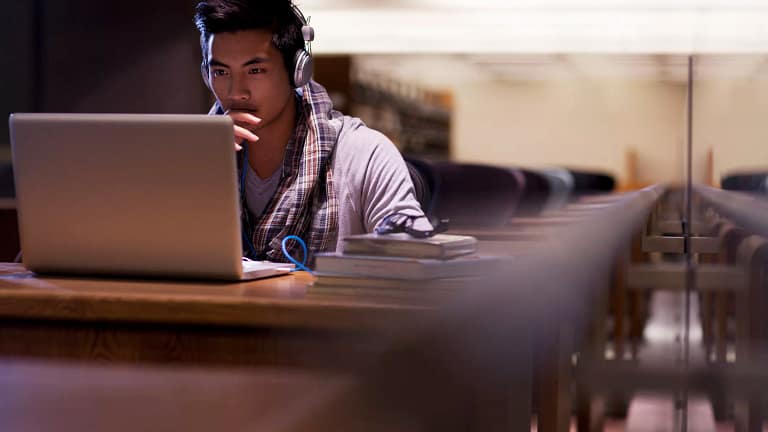 male college student a person at a laptop wearing headphones gettyimages .jpg