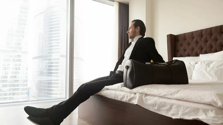 man in suit on hotel bed GCmlvmw.width .jpg