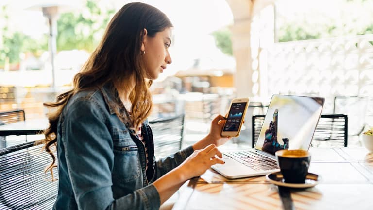 person sitting at a desk looking at laptop and phone.jpg