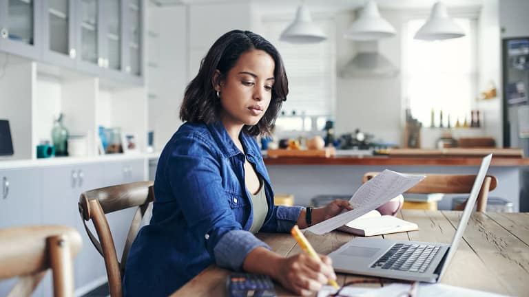 person sitting at a desk with a laptop and documents.jpg