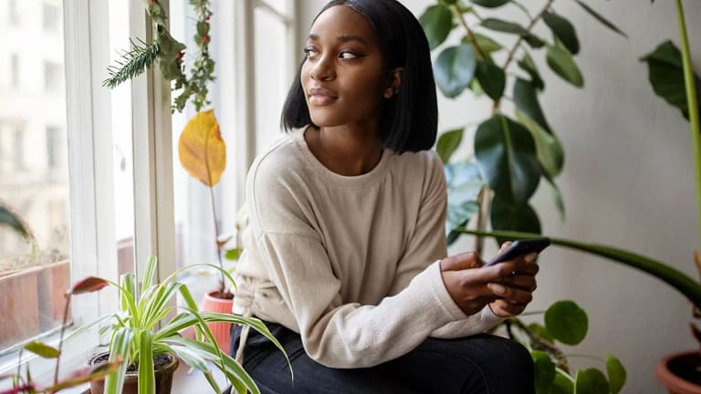 person with phone looking out window ZLNGso.width .jpg