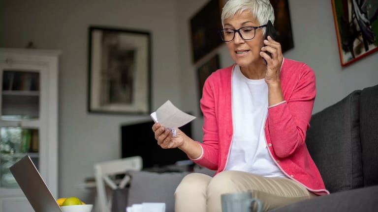 senior holding check and talking on phone.jpg
