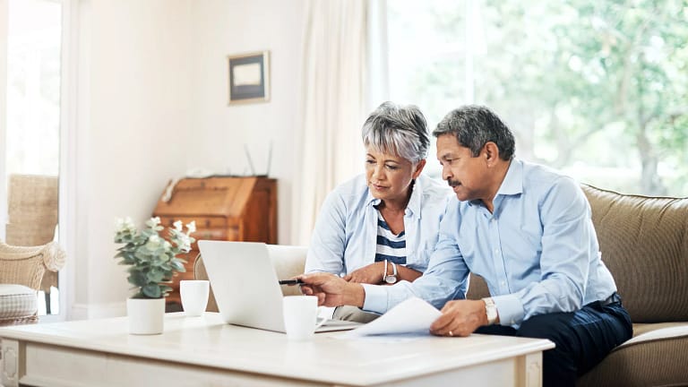 two older people sitting on a couch looking at a laptop copy.jpg