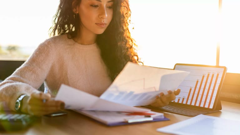 young woman sitting at a desk looking at charts.jpg