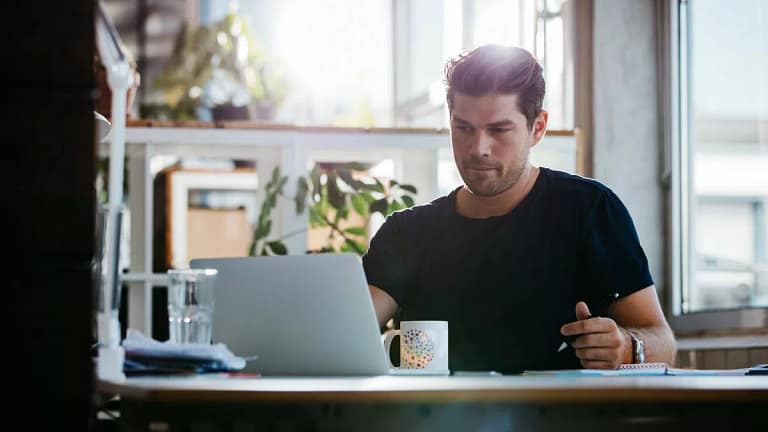 young man sitting at desk using laptop and th.width rNXRoV.jpg