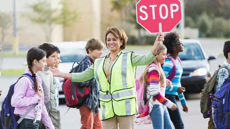 Crossing guard helping school children cross .width RDDdDn.jpg