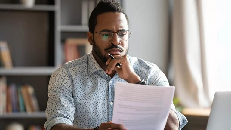 Man looking at documents with unsure expressi.width JzQldPC.jpg