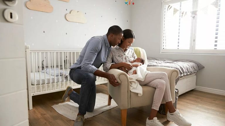 New parents holding baby in the nursery. Tca.width .jpg