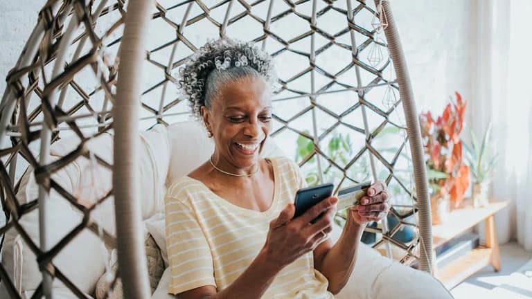 Senior woman holding a credit card and her ce.width ToyA.jpg