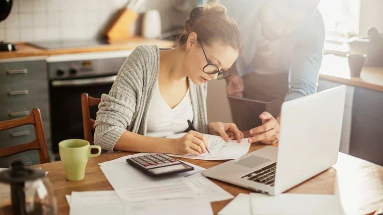 Woman with glasses making calculations VoscoL.width .jpg