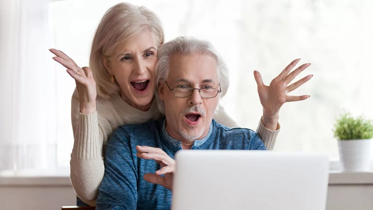 getty couple looking at laptop and exclaiming in happiness happy surprised thrilled.jpg