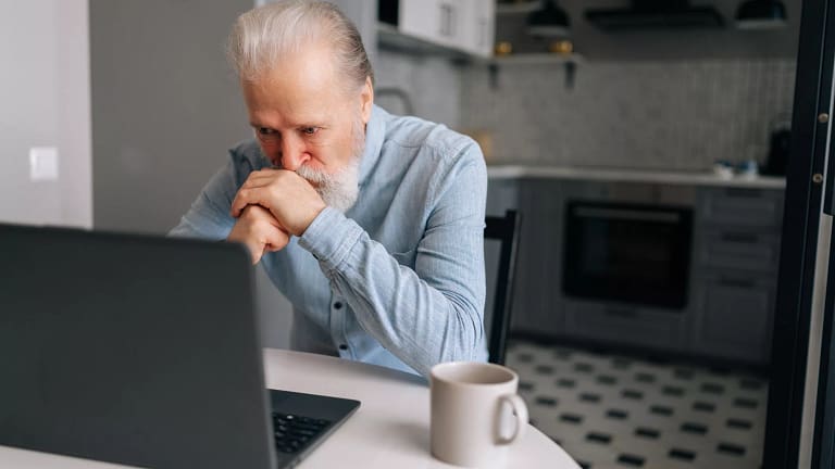 senior man laptop kitchen serious gettyimages .jpg