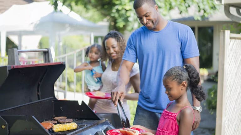 Family grilling hamburgers hotdogs and corn i.width .jpg