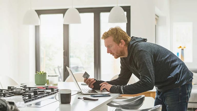 Man holding credit card and using laptop Hlq.width .jpg