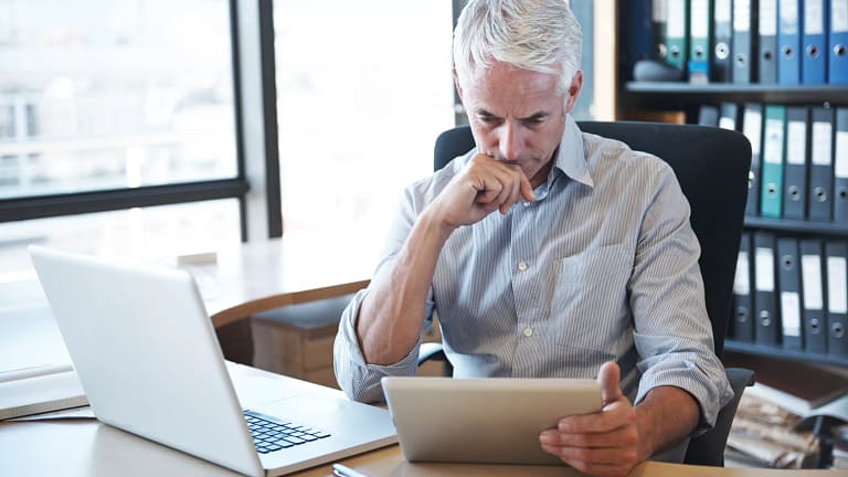 older man desk tablet serious gettyimages .jpg