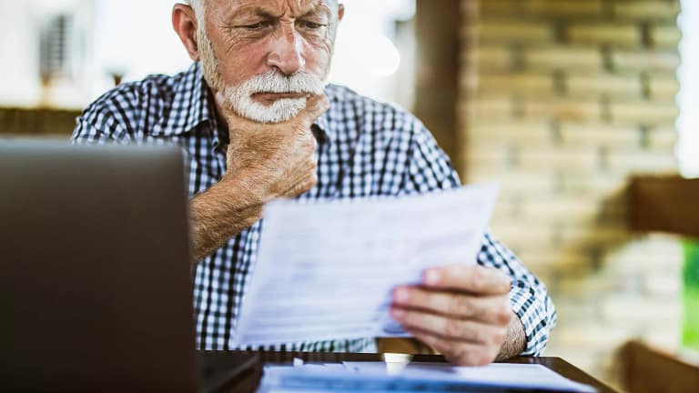 older man serious looking at document gettyimages .jpg