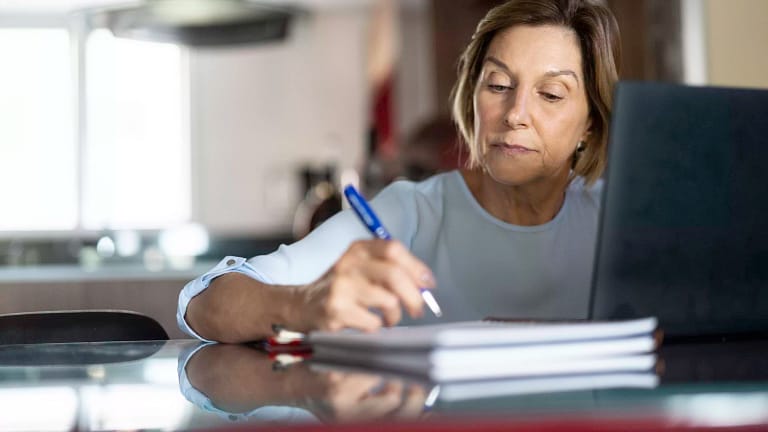 older woman taking notes laptop gettyimages .jpg