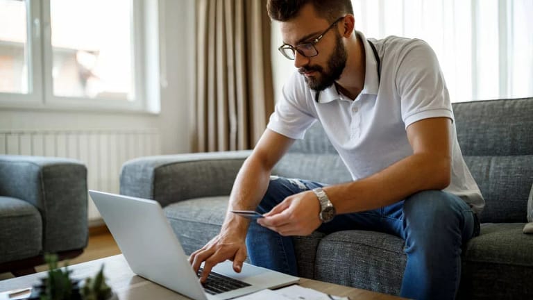 person on couch with laptop and credit card .width .jpg