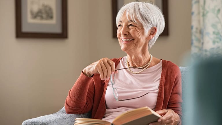 senior woman smiling book gettyimages .jpg