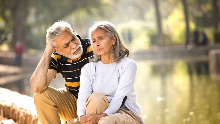 two older people sitting outside looking serious.jpg