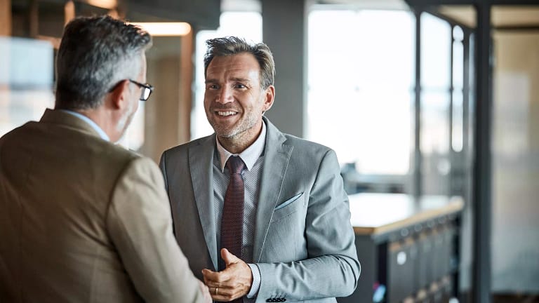 two people in business attire standing and talking gettyimages .jpg