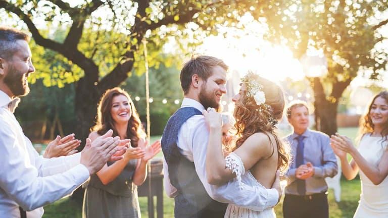 young bride and groom hugging in a backyard s.width .jpg