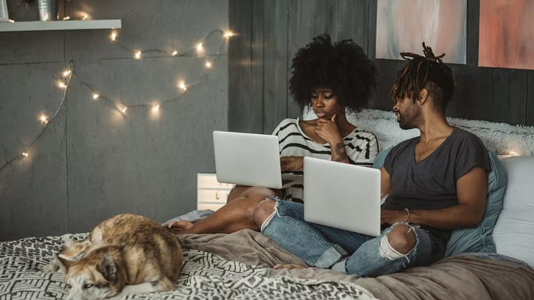 young couple on laptops in bedroom RrGguP.width .jpg