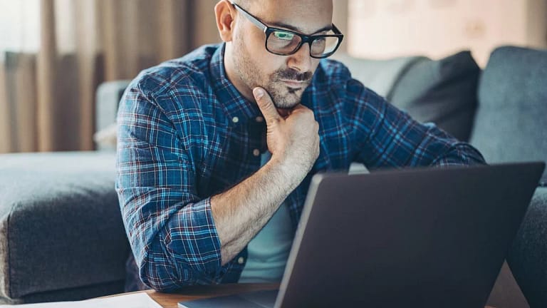 Man with glasses looking at laptop kjgn.width .jpg