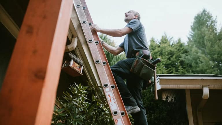 Man with tool belt climbing ladder to roof EJ.width .jpg