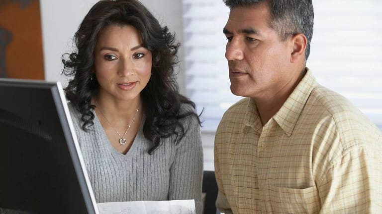Couple holding a document and looking at a co.width kcHOJq.jpg