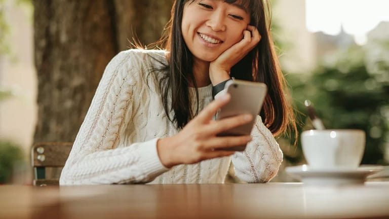 smiling person using smartphone TFngkG.width .jpg