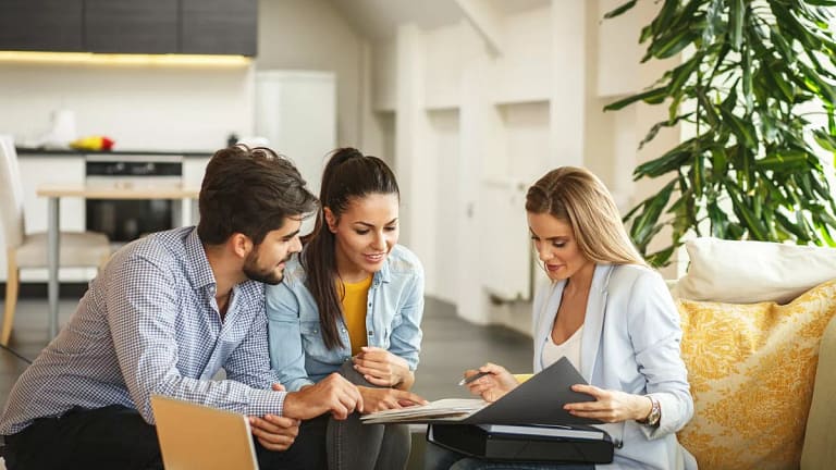 Couple signing paperwork with realtor.width .jpg