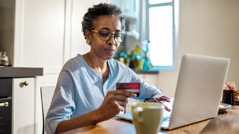Mature woman hold credit card thoughtfully wh.width yPgZIJ.jpg