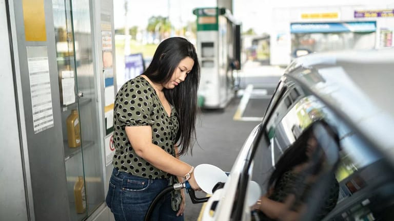 Woman refueling her car at a gas station tn.width .jpg