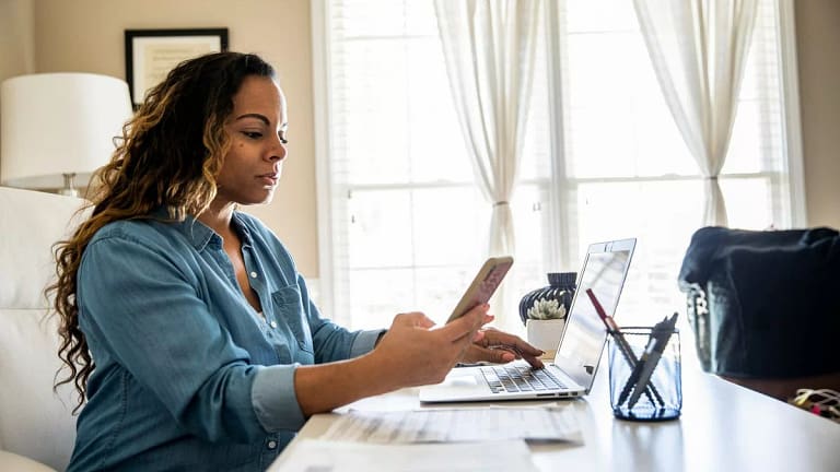 Woman using laptop and smartphone at home ToP.width .jpg