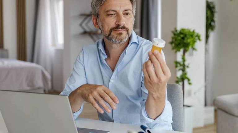 Adult person using laptop and looking at a pr.width .jpg