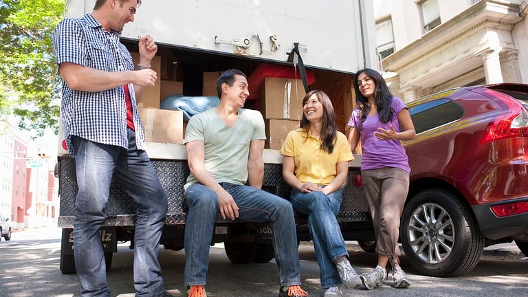 Four adults hanging out by loaded moving truc.width LAOTj.jpg