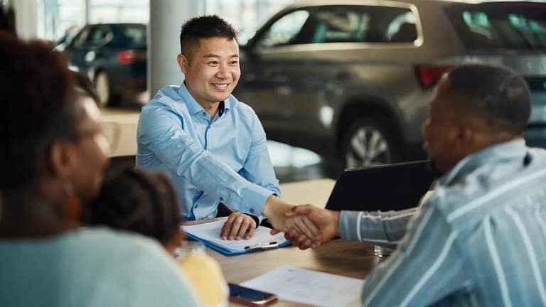 Salesman and customer shaking hands over pape.width .jpg