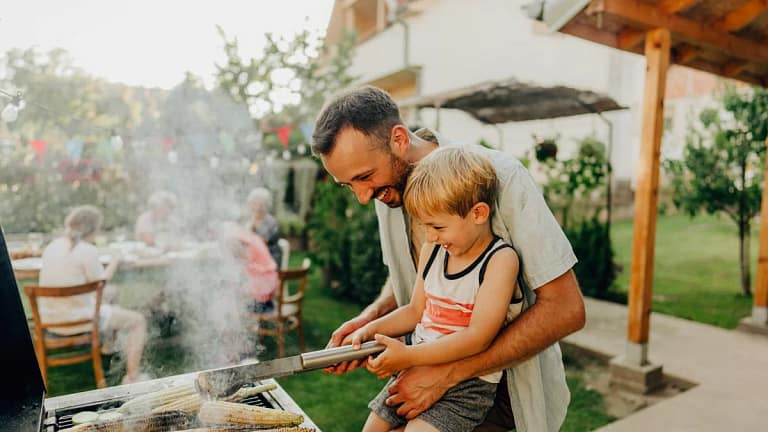 Father and son grill corn during a cookout on.width .jpg
