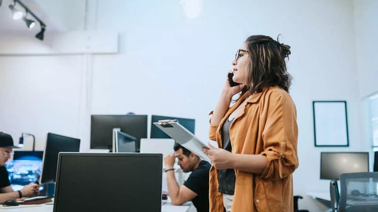 Woman in office holding clipboard and talking.width imFW.jpg